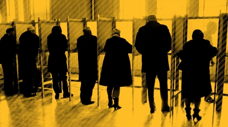 Men and women standing side by side in private voting booths, filling out election ballot papers, rear view.